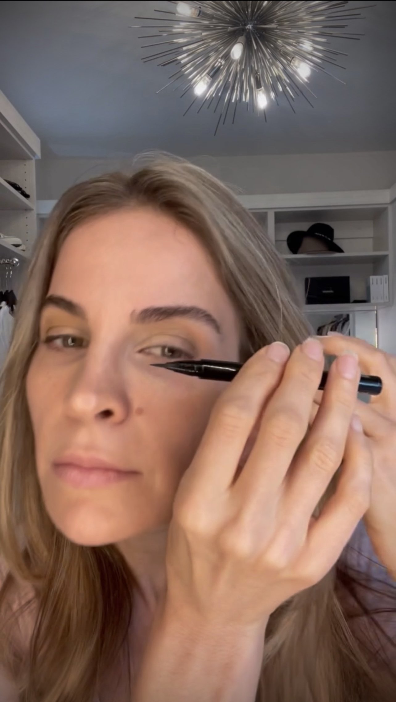 woman showing how to apply Black Liquid Eyeliner