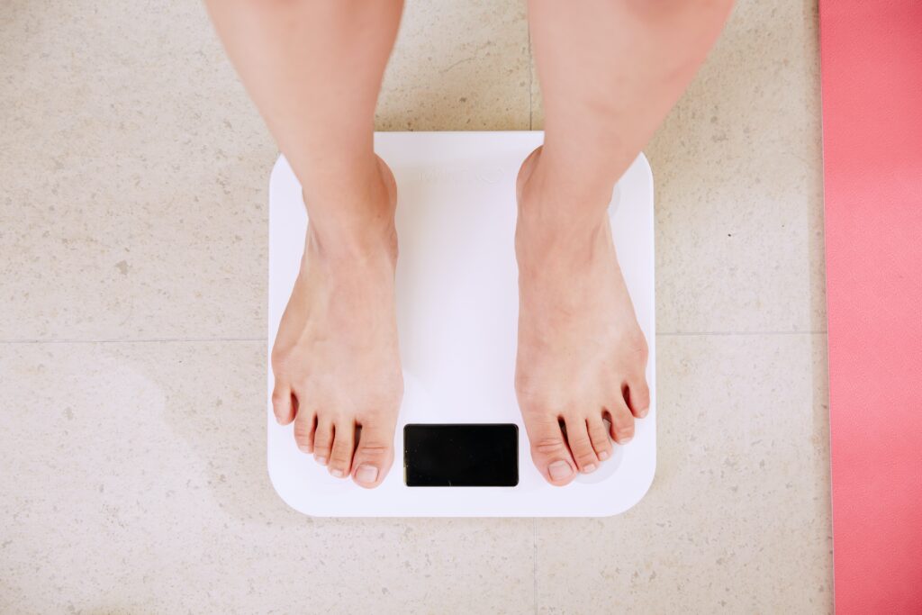 person weighing herself using Compounded Medication to loose weight